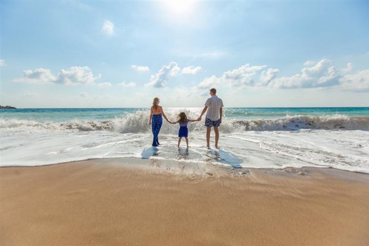 Familia caminando en la playa al atardecer