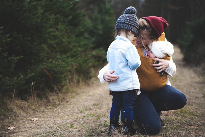 Madre abrazando a su hijo al aire libre